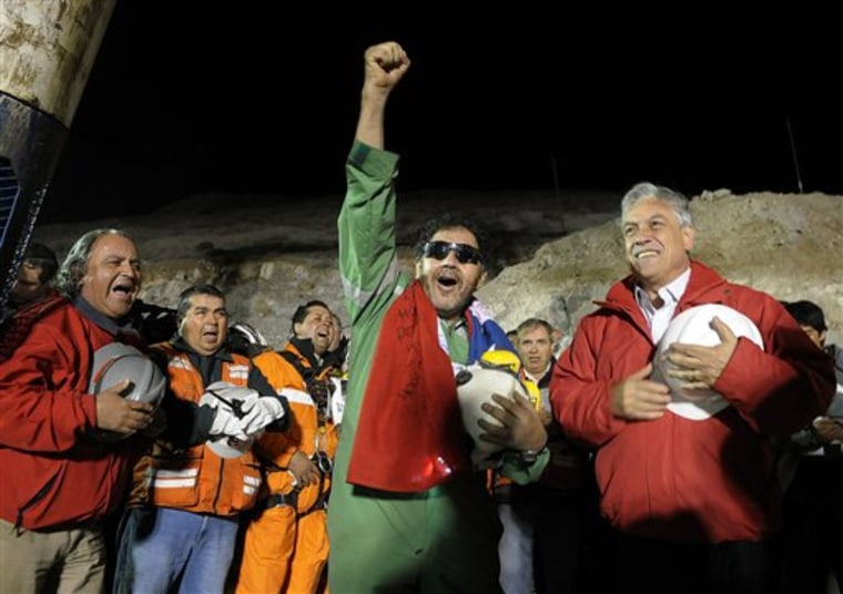 The last miner to be rescued, Luis Urzua, center, gestures as Chile's President Sebastian Pinera, right, looks on after his rescue from the collapsed San Jose gold and copper mine where he had been trapped with 32 other miners for over two months near Copiapo, Chile, on Oct. 13. 